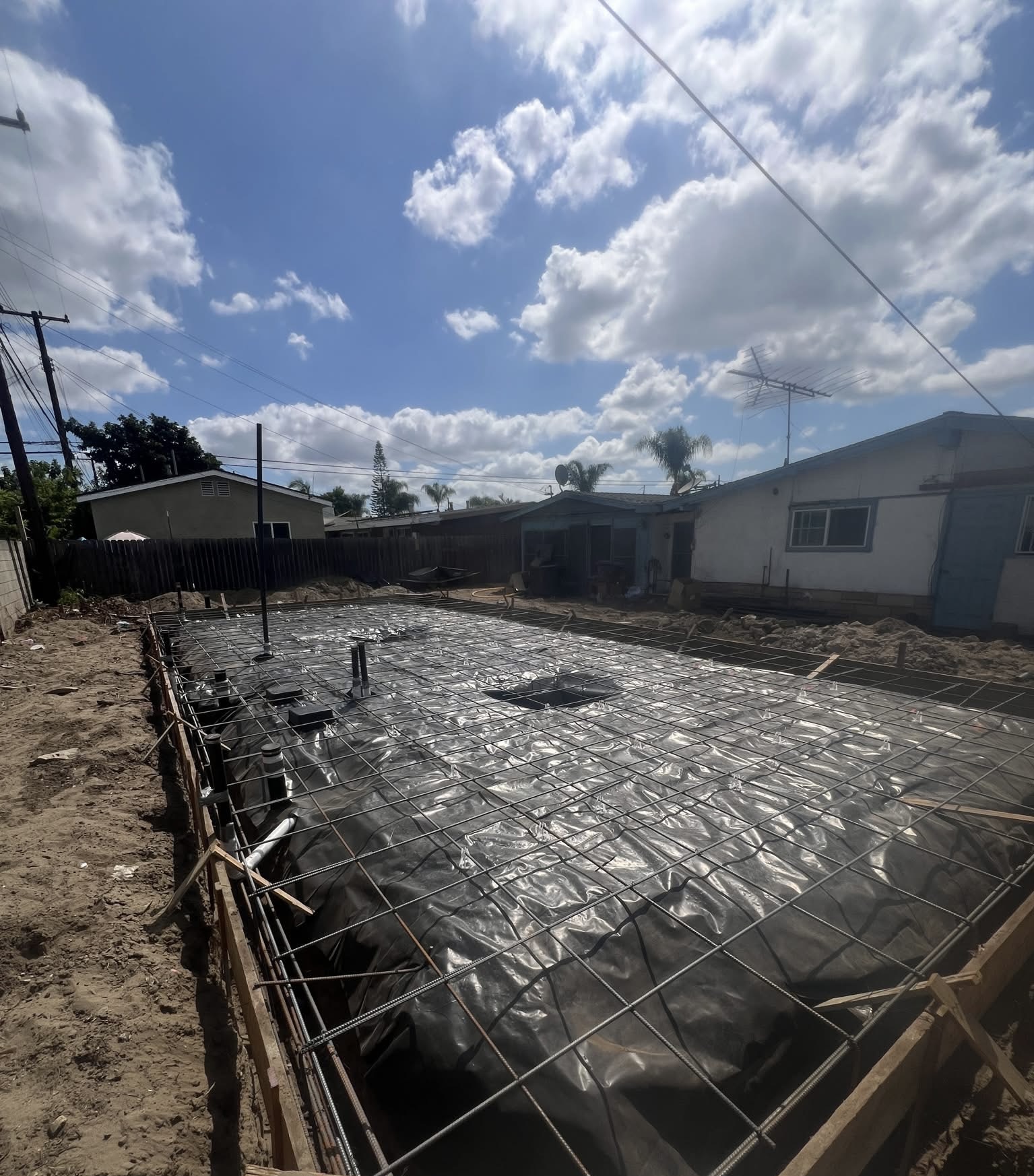 ADU construction — foundation stage, rebar grid and vapor barrier ready for concrete pour