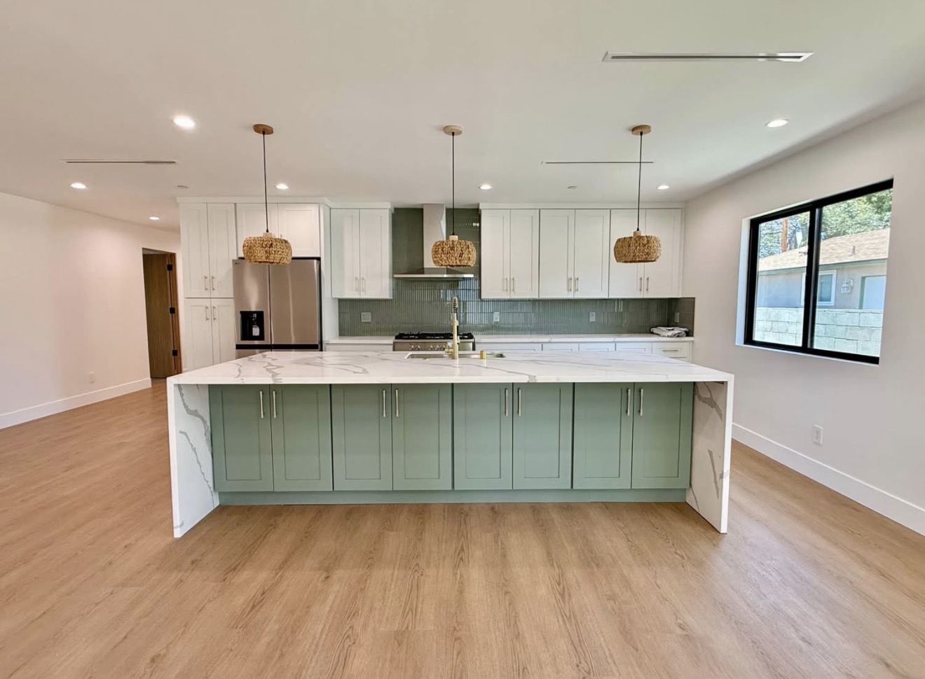 Sage green kitchen island with waterfall quartz countertop and glass tile backsplash kitchen renovation Southern California