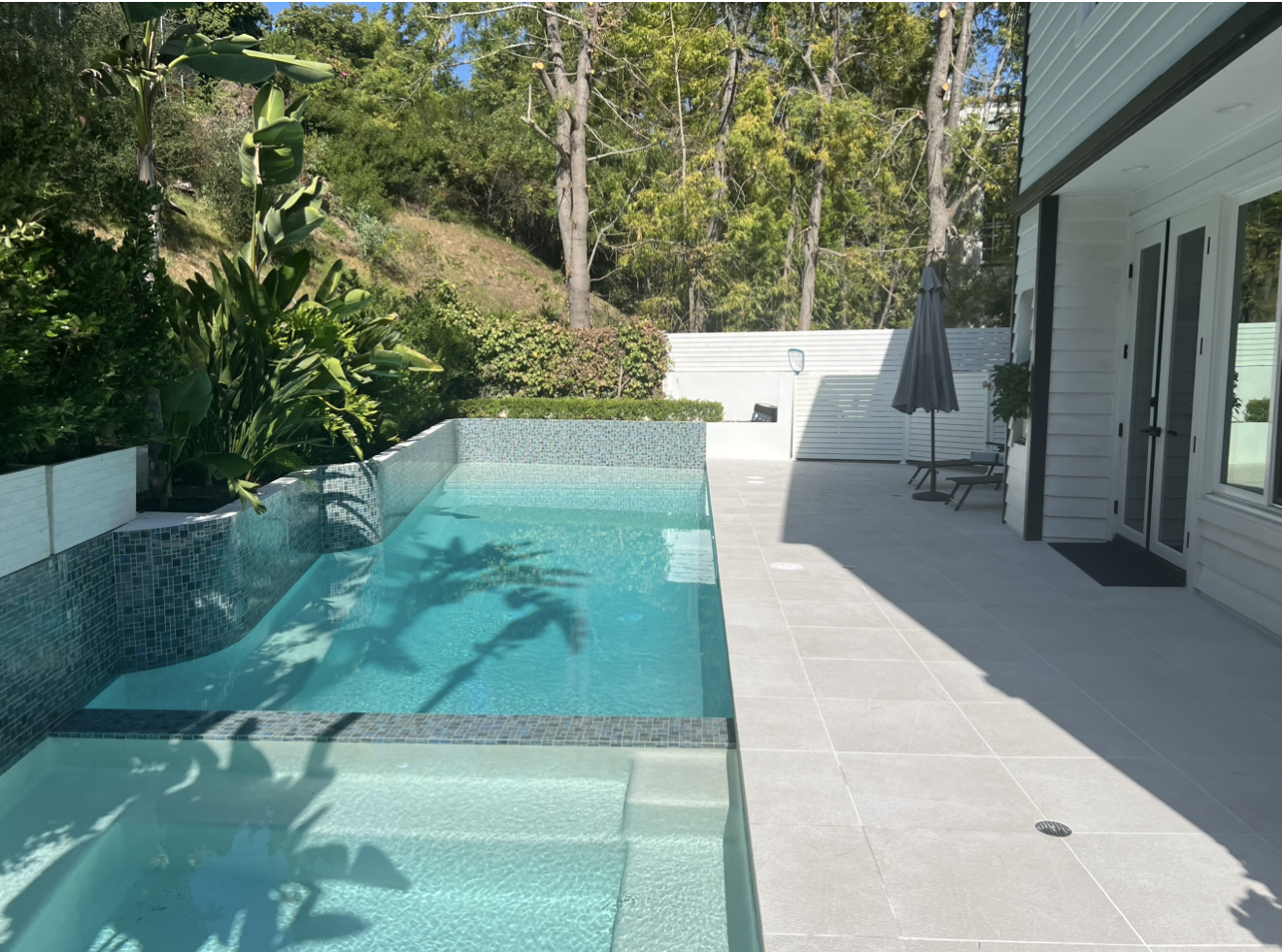Complete backyard and pool with glass tile and porcelain deck