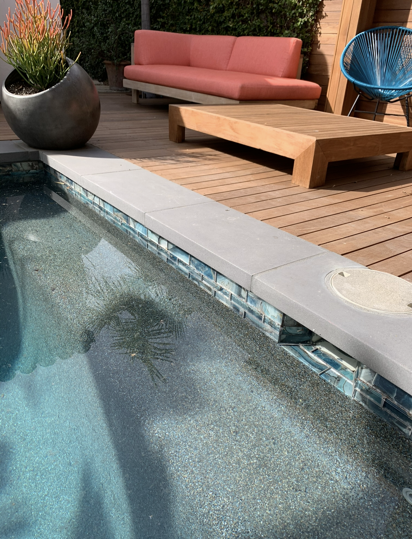Finished pool with wooden deck around glass tile
