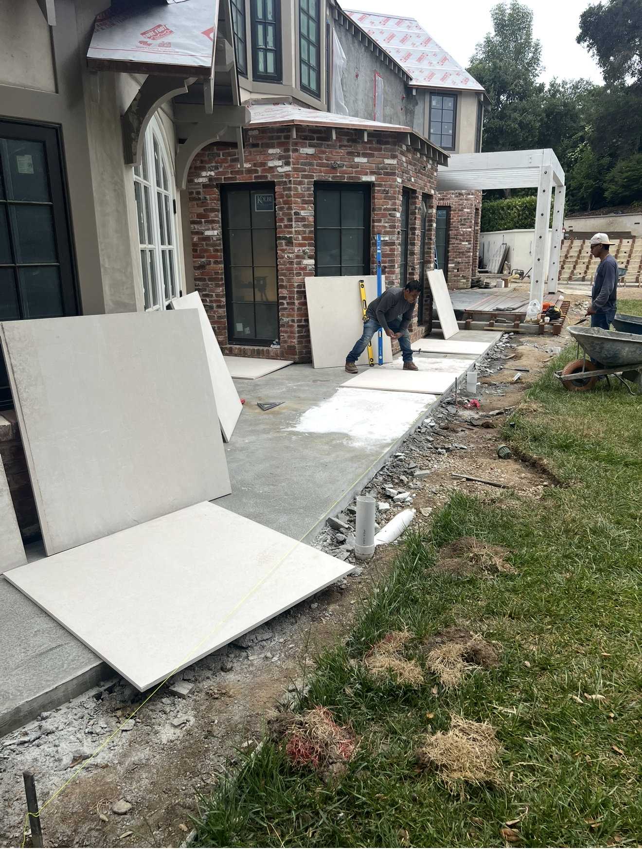 Imported 4x4 travertine pavers staged on site before installation on a Southern California backyard patio