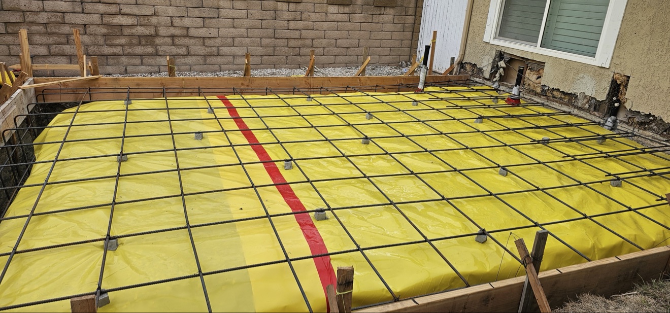 Slab foundation rebar grid over vapor barrier — home addition in Costa Mesa